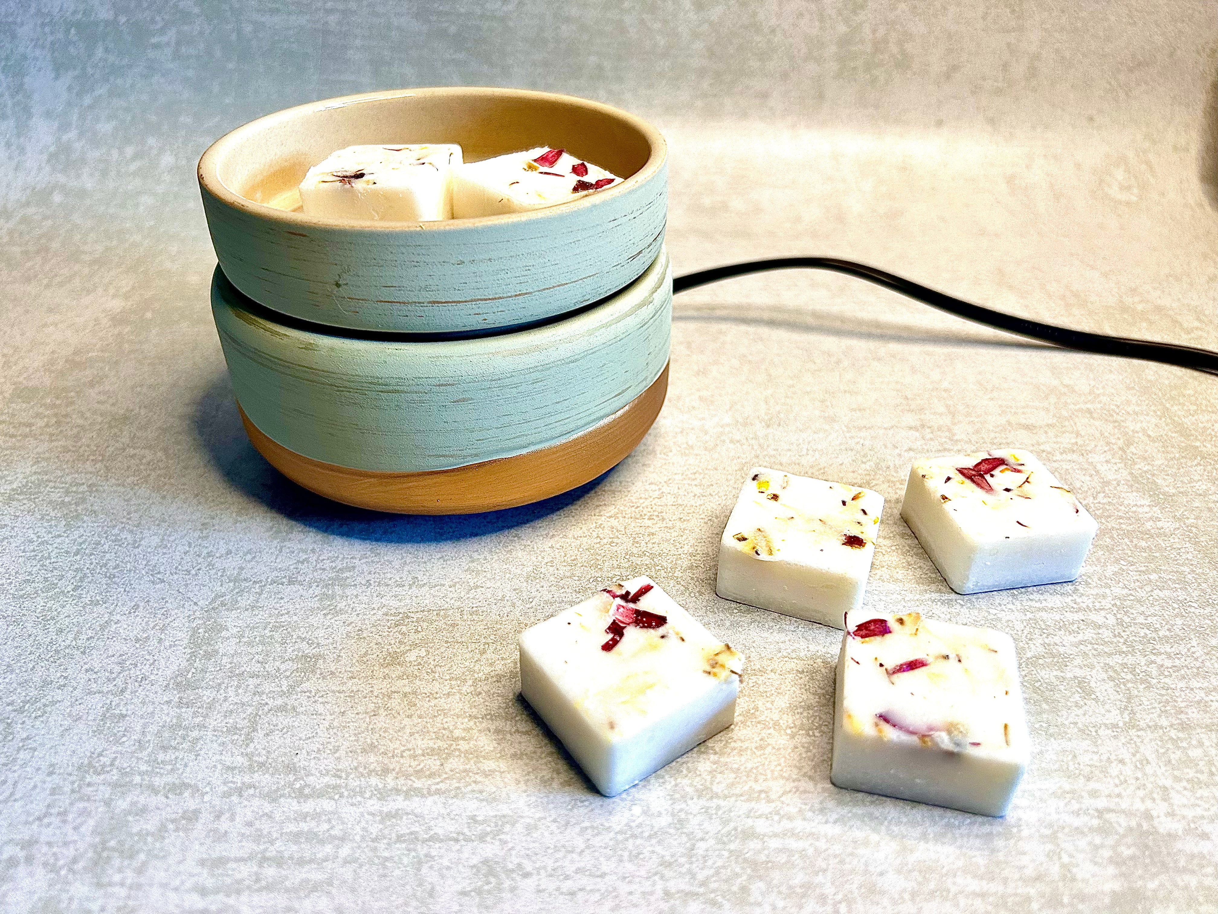 Electric Wax Melter in Sage Green with a cream dish, brown base and white wax melts in the dish and alongside.